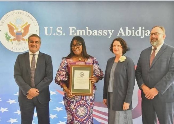 Madame Zeze Souassou Nicole Princesse Épouse Gohourou, maire de Guibéroua, pose avec son diplôme IVLP Agriculture aux côtés de diplomates, illustrant l’ouverture internationale de la commune.