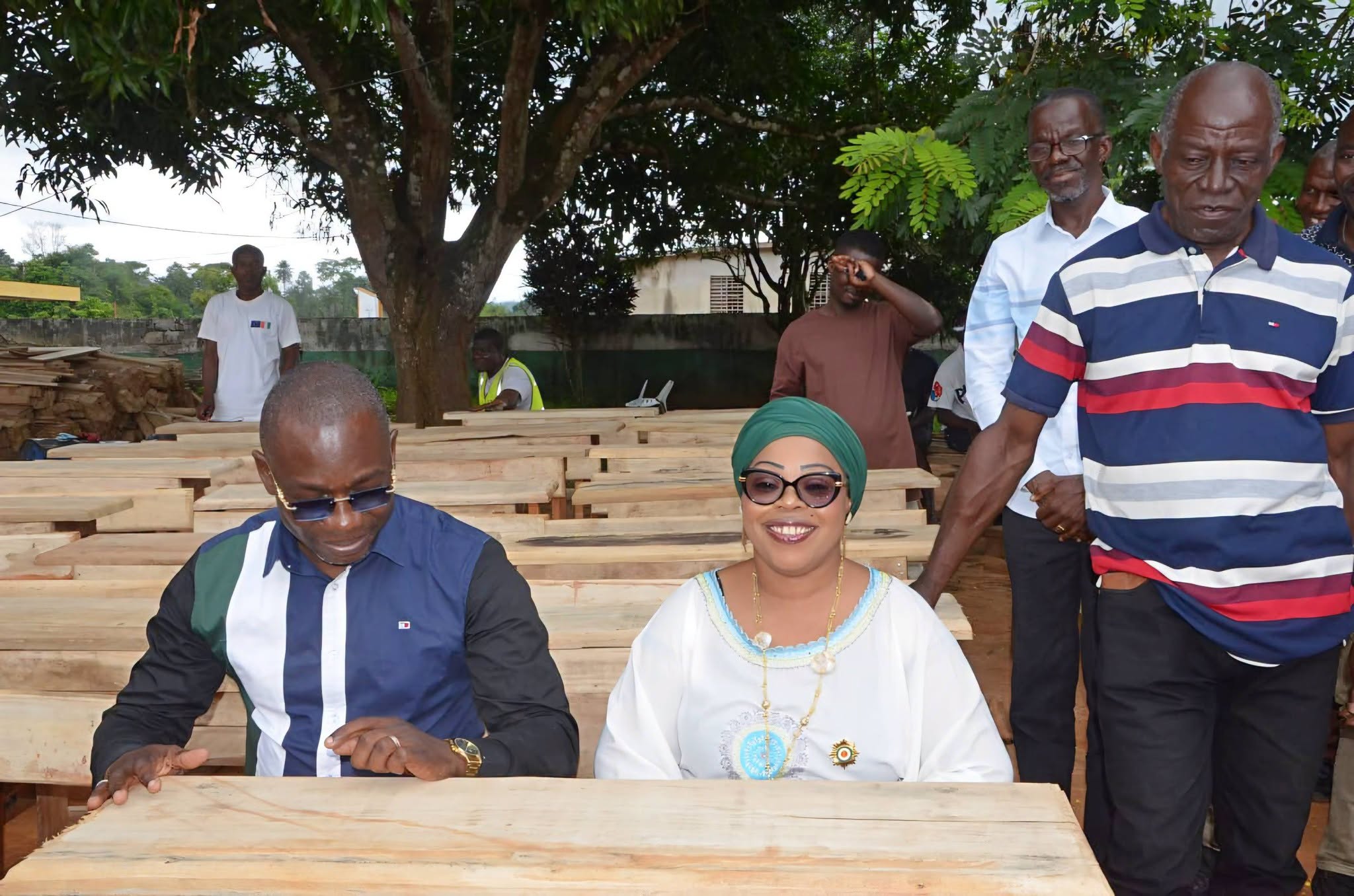 Madame le Maire teste elle-même l’un des tables-bancs remis aux écoles primaires de Logoualé.